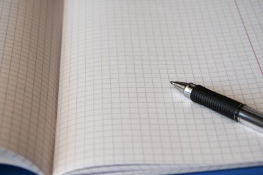 Siyah beyaz kompozisyonda defter ve kalem. Boşluğu kopyala, metin için yer. 