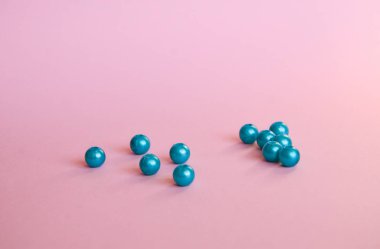 Yumuşak pembe arkaplan üzerinde parlak pembe incilerden oluşan güzel mavi bir grup.