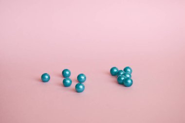 Yumuşak pembe arkaplan üzerinde parlak pembe incilerden oluşan güzel mavi bir grup.