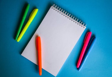 Mavi arkaplan ofis masası ve farklı nesnelerin boş kağıt sayfasının üst görünümü. Minimum düz yatay biçim kopyalama alanı, dizüstü bilgisayar 