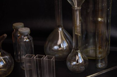 Siyah arka plandaki cam kimya laboratuarı ekipmanlarının analizi için farklı bir laboratuvar cam ve sıvıyla ayarlandı. Kimya Laboratuarı konsepti