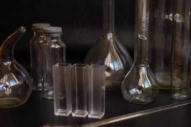 Siyah arka plandaki cam kimya laboratuarı ekipmanlarının analizi için farklı bir laboratuvar cam ve sıvıyla ayarlandı. Kimya Laboratuarı konsepti