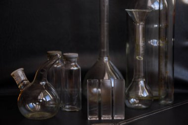 Siyah arka plandaki cam kimya laboratuarı ekipmanlarının analizi için farklı bir laboratuvar cam ve sıvıyla ayarlandı. Kimya Laboratuarı konsepti