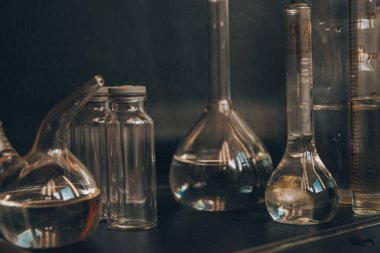 Siyah arka plandaki cam kimya laboratuarı ekipmanlarının analizi için farklı bir laboratuvar cam ve sıvıyla ayarlandı. Kimya Laboratuarı konsepti