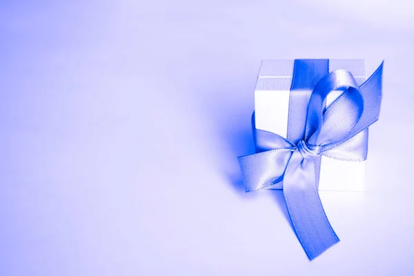 white present boxes with blue ribbon on the classic blue pantone background. christmas or valentines day white gift box