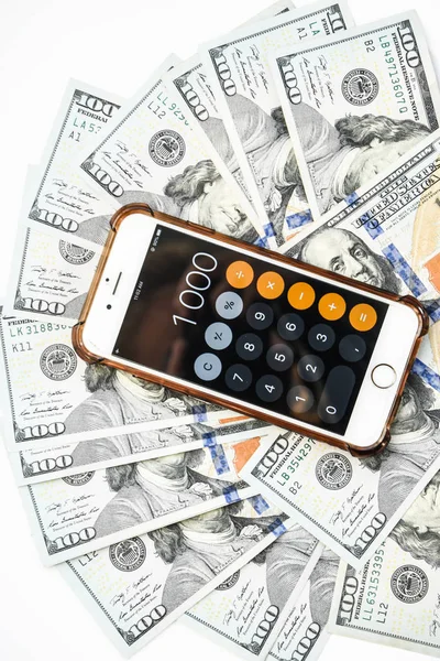 Close-up of Money and Calculator with One thousand on the Display ,It is a lot of One hundred dollars banknotes pile with calculator