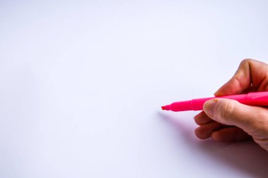 Bir kalem tutan ve beyaz arka plana bir şeyler yazan bir el.