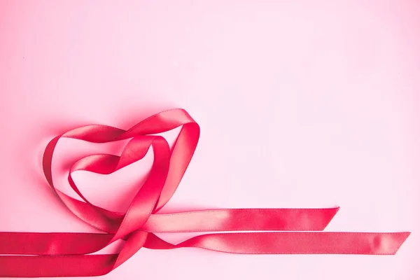 pink gift ribbon in the shape of heart on the pink background, st valentines day, love concept,