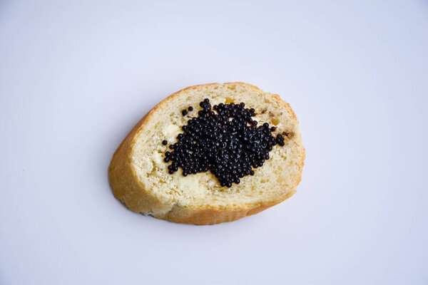 one sandwich with black caviar isolated on the white background