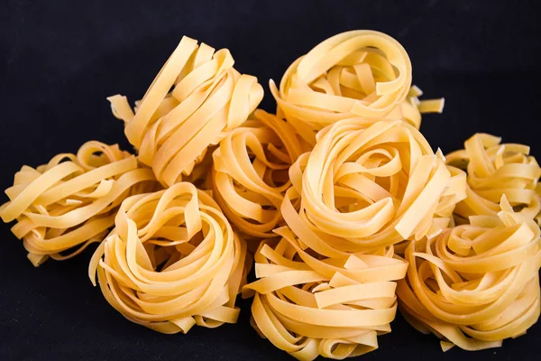 Pasta all 'uovo, Pasta Tagliatelle, Bolas redondas de pasta cruda sobre fondo negro — Foto de Stock