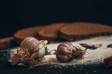 Beyaz buğday ununa işlenmiş fırın. Dilimlenmiş çavdar ekmeği ve koyu arkaplan sarımsağı.