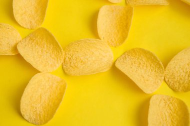 Sarı arka planda lezzetli patates cipsi.