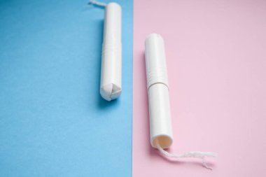 Mavi ve pembe arka planda hijyenik tamponlar. Fotokopi alanı, kadınların hijyen koruması için adet öncesi hijyenik tampon. Kritik günler. Tıbbi kavram