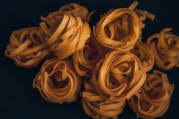 Pasta all\'uovo, Tagliatelle Pasta, Round balls of raw pasta on black background