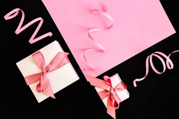 Cajas de regalo con cinta rosa sobre fondo rosa y negro —  Fotos de Stock