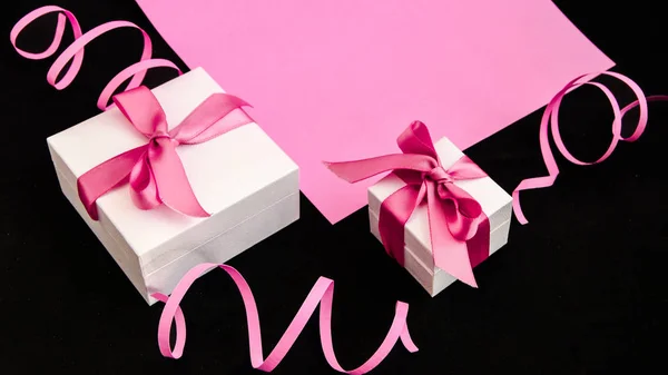 Cajas de regalo con cinta rosa sobre fondo rosa y negro —  Fotos de Stock