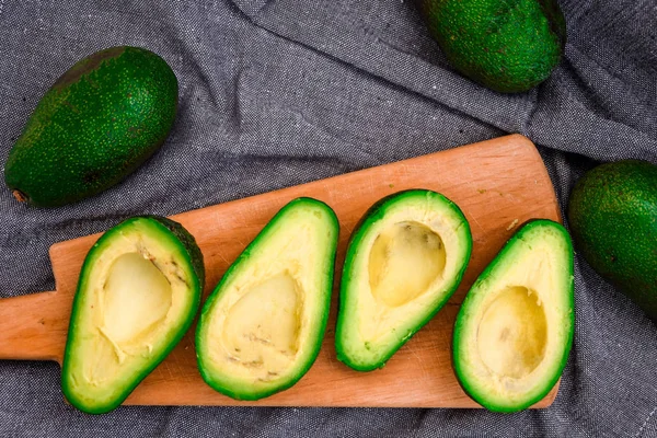 Taze avokado, olgun avokado ve avokadoyu kemikle keser. Boşluğu kopyala, üst görünüm — Stok fotoğraf