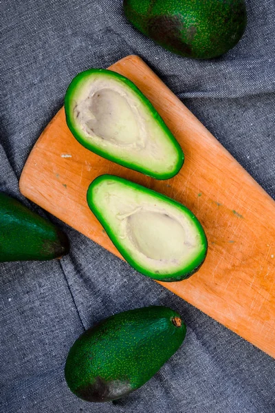 Avocado su un tagliere di legno. avocado, verdura, cibo, biologico, verde, vegetariano — Foto Stock