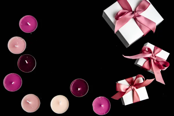 Espacio de copia para cajas de regalo de texto con cinta rosa y velas sobre fondo negro —  Fotos de Stock