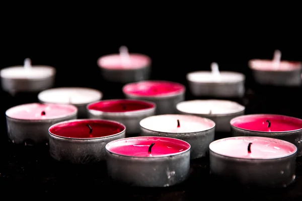 在黑色的背景上躺着一束粉红的茶色石蜡蜡烛. — 图库照片