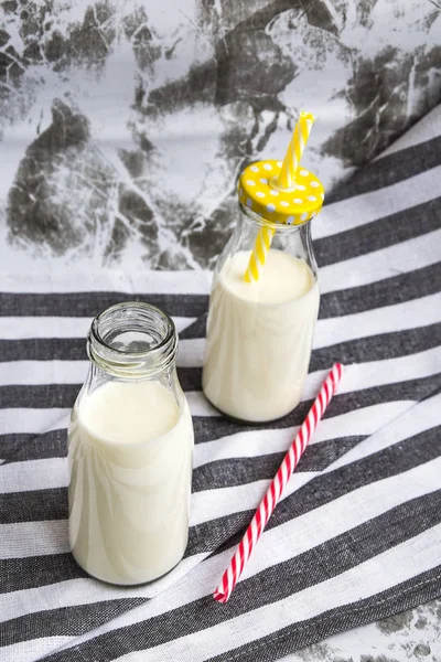 Пляшка свіжого молока на столі з кухонним рушником — стокове фото