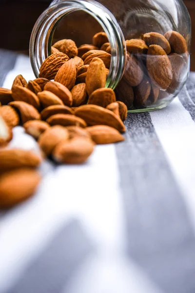 close up Peeled almonds nut in small glass jar on