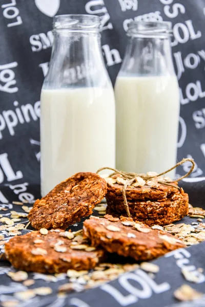 Oves a arašídové máslo sušenky, zblízka s lahvemi mléka — Stock fotografie