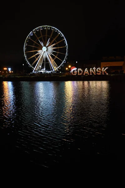 Utsikt över staden på natten med lampor på vattnet, pariserhjul — Stockfoto