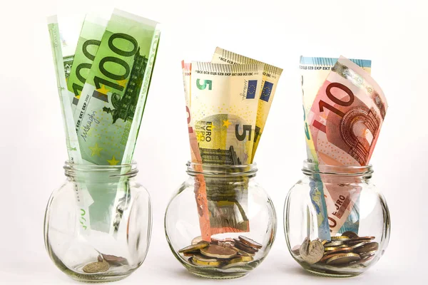 Frascos de vidro preenchidos com moedas e notas de euro, poupança dentro frasco de vidro, dinheiro isolado em branco — Fotografia de Stock
