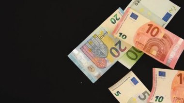 Falling Euro banknotes on black background,