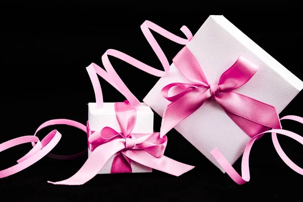 Geschenkdozen met roze lint en decoraties op de donkerzwarte achtergrond — Stockfoto