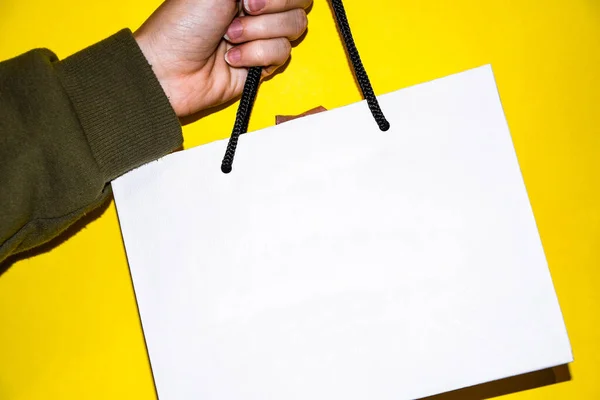 Bolso para llevar a mano femenino blanco sobre fondo amarillo, espacio para copiar — Foto de Stock
