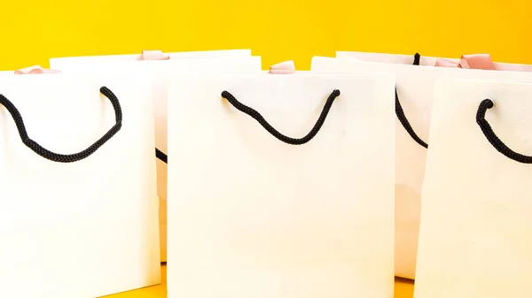 一套白色纸袋 用于黄色背景的购物 复制空间 购物袋和普通文本或产品的复制空间的模型 — 图库照片