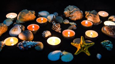 Mumlar, taşlar ve kabuklar kaplıcada, geceleri ışık, deniz kaplıcası konsepti, spa tedavisinin bileşimi, seçici odak noktası