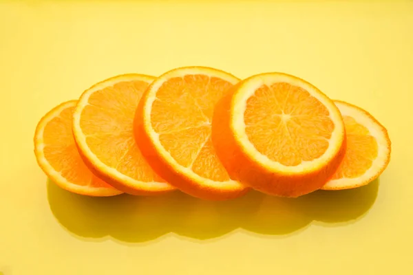 Fresh and Juicy Orange fruit slices on the yellow background, healthy food