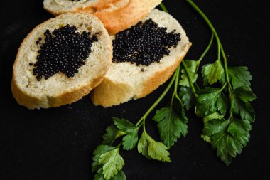 Siyah havyarlı, siyah maydanozlu, baget dilimli ve havyarlı üç lezzetli sandviç.