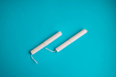 Mavi arka planda hijyenik tamponlar. Fotokopi alanı, kadınların hijyen koruması için adet öncesi hijyenik tampon. Kritik günler. Mavi arka planda tıbbi gebelik, günlük, adet gören kadın.