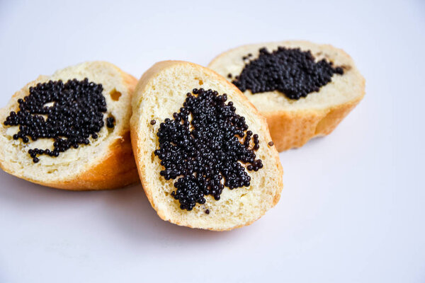 Three sandwiches with black caviar isolated on the white background Luxurious culinary delicacy