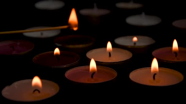 Primer plano de la vela candente encendida agrupada sobre fondo negro. Ambiente romántico — Vídeos de Stock