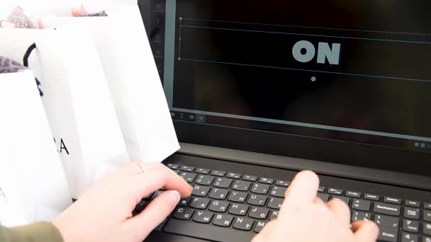 Női kézi nyomtatás Online vásárlás laptop, bevásárló táskák a háttérben — Stock videók