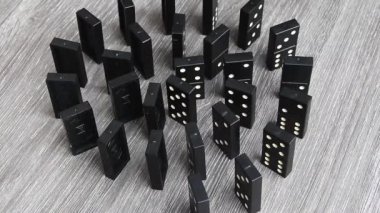 dominoes falling in a row, hand pushes a Domino and starts a chain reaction on wooden background Slow motion. Dominoes. Chain reaction. The Domino Principle