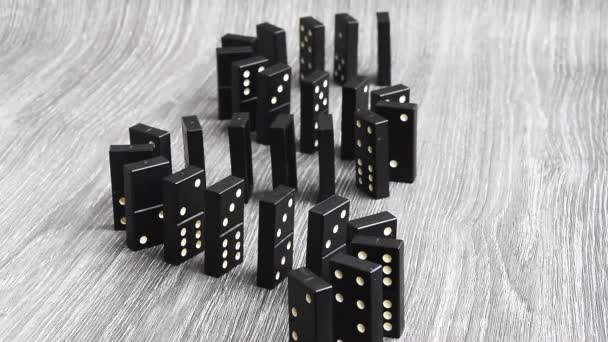 Dominoes falling in a row, hand pushes a Domino and starts a chain reaction on wooden background Slow motion. Dominoes. Chain reaction. The Domino Principle — Stock video