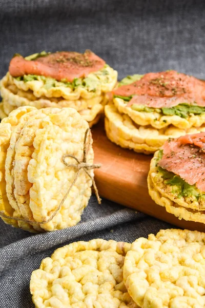 Snacks from rice cookies, salmon, avocado and spices on cutting board, Healthy snack , Breakfast, Vegetarian food, Dieting, gluten free bread, guacamole