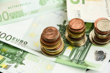 Euro coins on banknote money background, a coin on the background of stacks of coins and banknotes