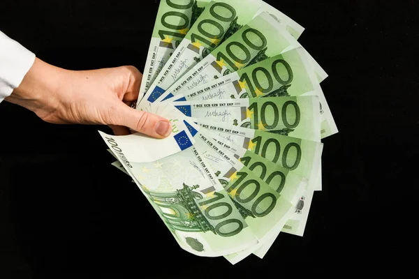 hand with euro isolated on black background, Hand holding euros, Trading Business Theme, one hundred money banknotes, Businessman with One Hundred Euro Banknotes