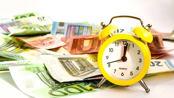 Alarm clock with paper euro money 10, 20, 50, 100, alarm clock on banknotes, Time is money, Time to make money. Alarm clock and dollars, Clock standing on the money