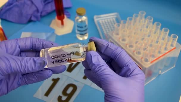 Вчений тримає пляшку вакцини, розробленої для вірусу корона. Протиотрута Covid-19. Доктор виявляє лікування від епідемічних захворювань . — стокове відео