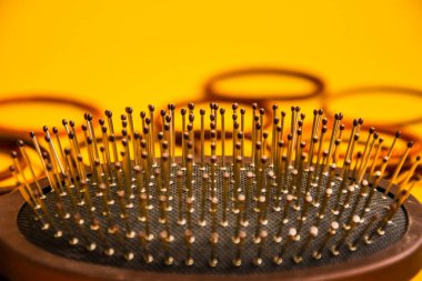 Güzellik salonu çalışma masasındaki taraklar ve kuaför aletleri sarı arka plan üst görünüm alanı metin, profesyonel araçlar, saç lastiği için