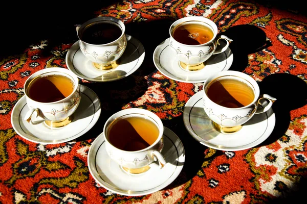 土耳其地毯上有茶托的老式苏格兰人茶杯 传统的茶道 有深深阴影的阳光 — 图库照片