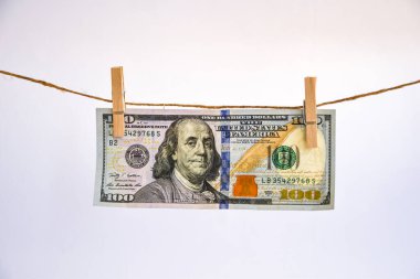 Bir ipe 100 dolar, beyaz arka planda izole edilmiş bir ipe takılmış dolar para aklama konsepti. Dolarlar ipte kurumuş. Yıkandıktan sonra dolar. Dürüstçe kazanılan para. Paranın yasallaştırılması. t 'ye iliştirilmiş notlar paketi